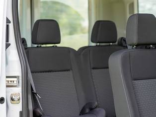 Ansicht der hinteren Sitzreihen eines Ford Transit bei geöffneter Seitentür