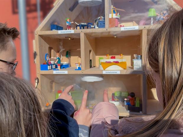 Kinder stehen vor einem Rauchhaus und sind begeistert und zeigen mit den Fingern drauf