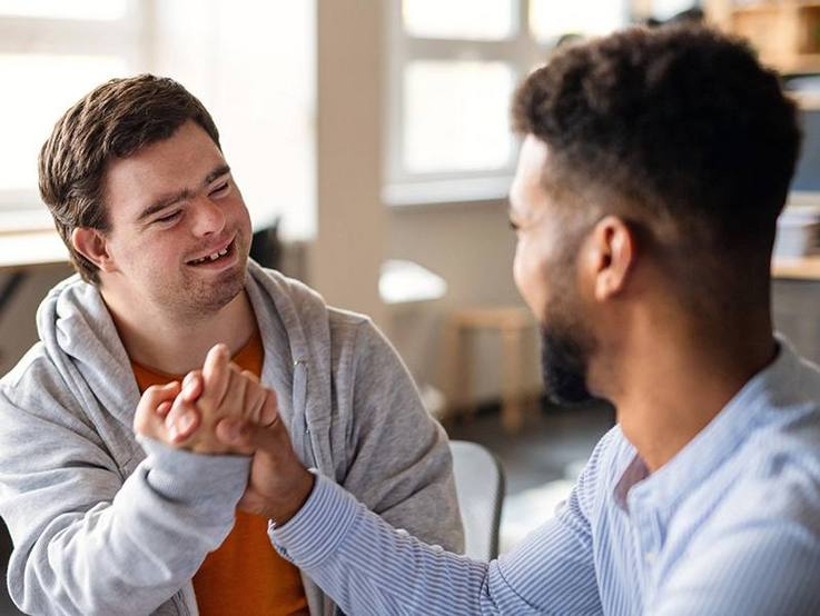Handschlag zweier junger Männer - CARITIVA fördert Inklusion