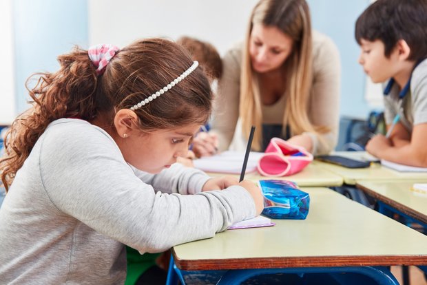 Mädchen am Schreibtisch in der Schule