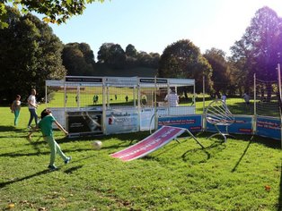 Junge schießt auf Fußballrampe auf Rasen