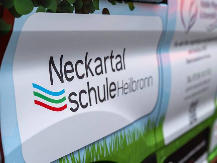 Neckartalschule - foliertes Logo der Schule auf dem gesponsorten Ford Transit Kombi L2/H2 9-Sitzer