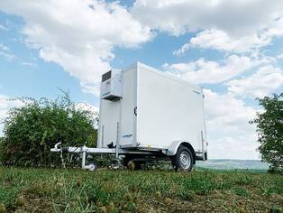 Kühlanhänger Ansicht von rechts vorn auf dem Wiesenhügel