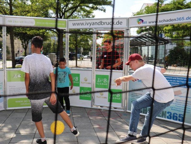 Kinder spielen Fußball im Cage
