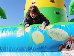 Hüpfburg Jungle open air - ein Mädchen erklettert den Rand der Hüpfburg