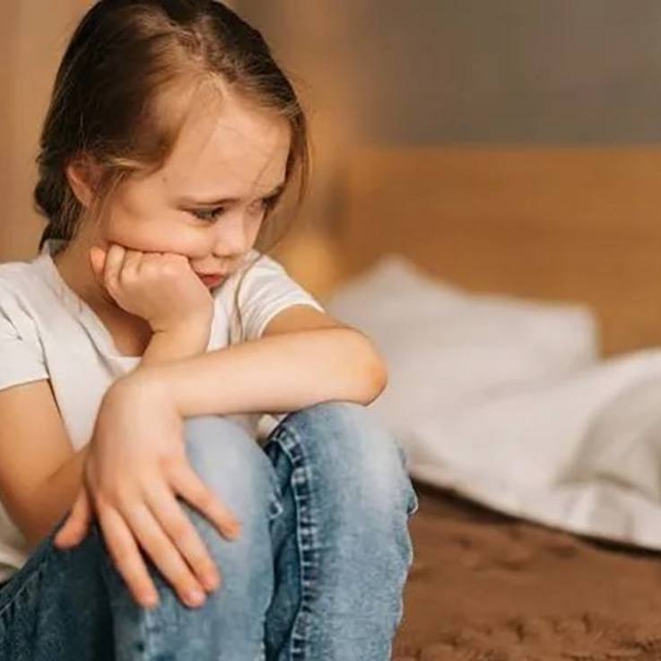 Nachdenkliches, traurig wirkendes, sitzendes Mädchen