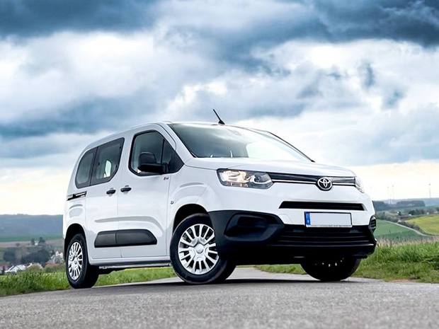 Toyota Proace City auf asphaltiertem Feldweg unter wolkigem Himmel