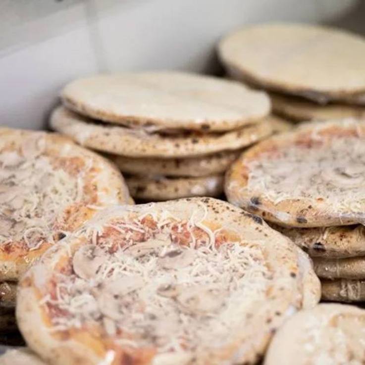 Gestapelte Tiefkühlpizzen in Folie