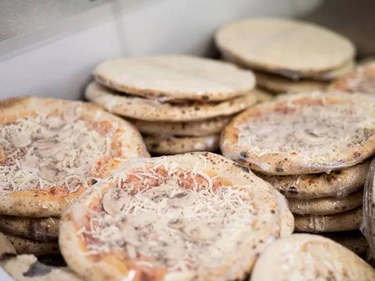 Gestapelte Tiefkühlpizzen in Folie