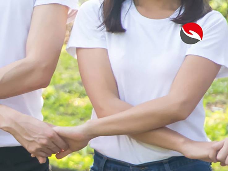 Die Arme gekreuzt einander die Hände reichen