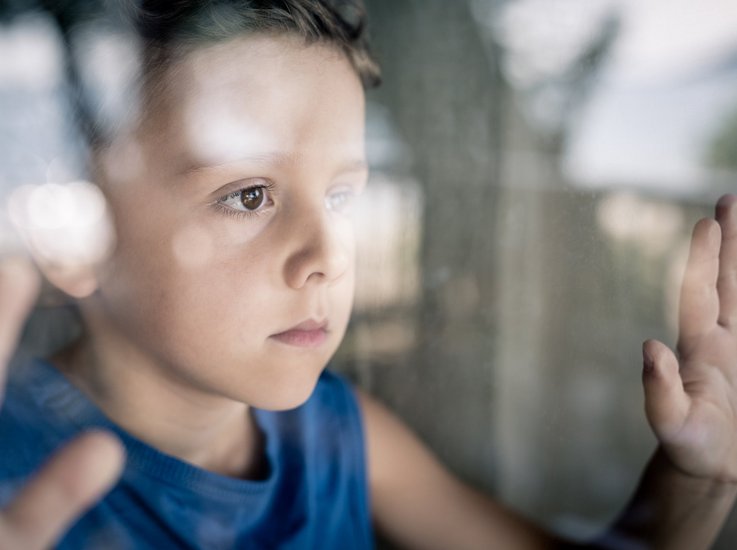 Junge hinter Fenster