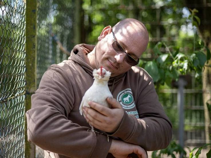 Manuel Ferkau, 1. Vorsitzender des Tierschutzvereins Hattersheim, mit Huhn auf dem Arm