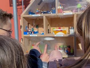 Rauchhaus Nahaufnahme mit Rauchbildung in Räumen hinter der Schutzscheibe - drei Kinder zeigen mit dem Finger auf den Rauch