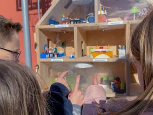 Rauchhaus Nahaufnahme mit Rauchbildung in Räumen hinter der Schutzscheibe - drei Kinder zeigen mit dem Finger auf den Rauch